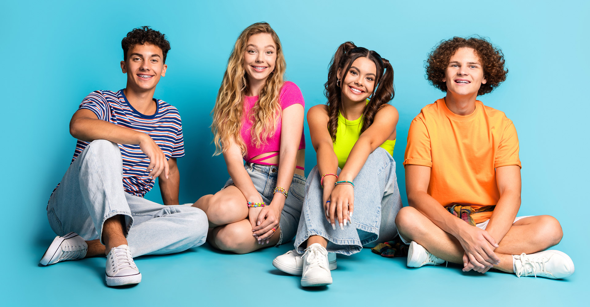 Group of diverse friends sitting on a blue background | Cedar Park Smiles