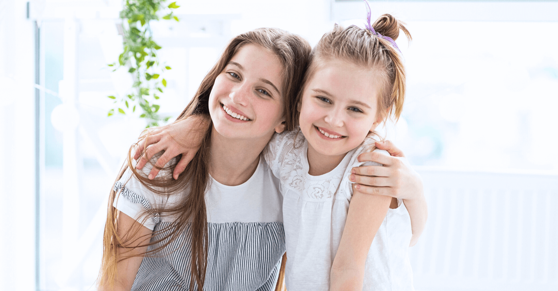 Two young girls hugging and smiling | Cedar Park Smiles