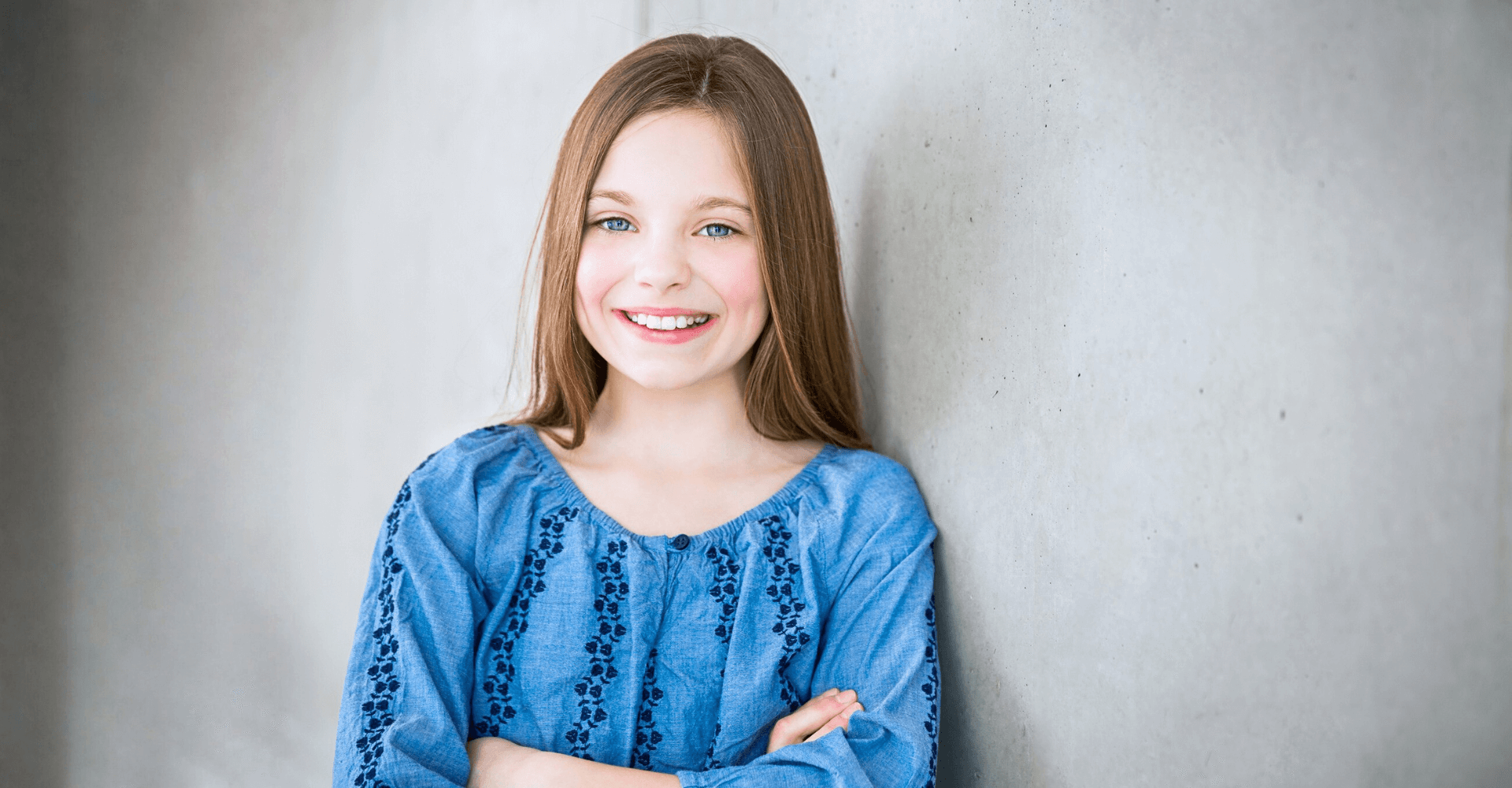 Young girl in a blue patterned shirt smiling | Cedar Park Smiles